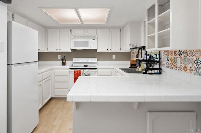 4525 Mississippi St Unit 2, San Diego, CA 92116 - kitchen featuring white appliances, a peninsula, light wood finished floors, tile countertops, and white cabinetry