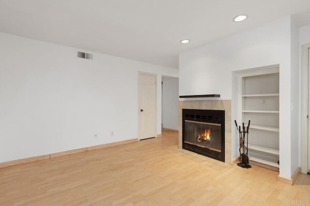 4525 Mississippi St Unit 2, San Diego, CA 92116 - unfurnished living room with a tile fireplace, wood finished floors, recessed lighting, and built in shelves
