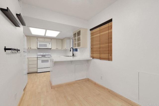 4525 Mississippi St Unit 2, San Diego, CA 92116 - kitchen featuring white appliances, tile counters, a peninsula, light wood-style floors, and a breakfast bar area
