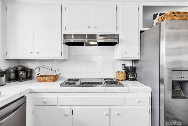 54832 Benecia Trl, Yucca Valley, CA 92284 - kitchen featuring appliances with stainless steel finishes, under cabinet range hood, white cabinets, and tile counters