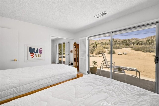 54832 Benecia Trl, Yucca Valley, CA 92284 - carpeted bedroom featuring access to exterior and a textured ceiling