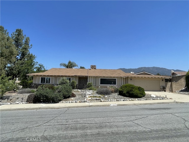 2343 Navarro Dr, Claremont, CA 91711 - single story home featuring a garage, driveway, a mountain view, and a chimney