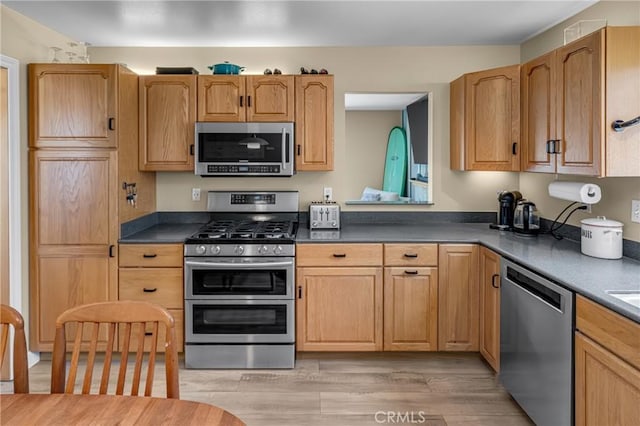 17632 Prescott Ln, Huntington Beach, CA 92647 - kitchen featuring stainless steel appliances, light wood-type flooring, and dark countertops