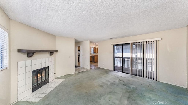14927 Condon Ave Unit 7, Lawndale, CA 90260 - unfurnished living room featuring plenty of natural light, a tile fireplace, carpet flooring, and a textured ceiling