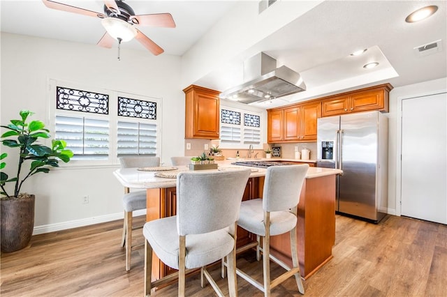 8761 Sandhill Dr, Riverside, CA 92508 - kitchen featuring exhaust hood, stainless steel appliances, light countertops, and plenty of natural light