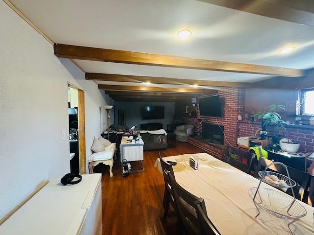 9167 Citrus Ave, Fontana, CA 92335 - dining space with beam ceiling, a brick fireplace, and wood finished floors