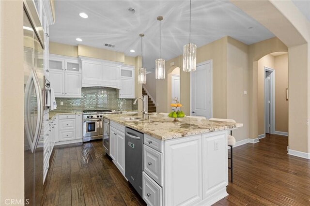 17472 Oakbluffs Ln, Huntington Beach, CA 92649 - kitchen featuring arched walkways, appliances with stainless steel finishes, dark wood-type flooring, white cabinets, and recessed lighting