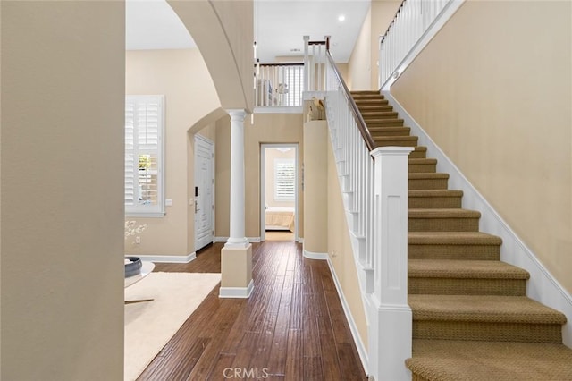 17472 Oakbluffs Ln, Huntington Beach, CA 92649 - entrance foyer featuring arched walkways, decorative columns, hardwood / wood-style flooring, and stairway