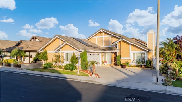 3718 Berkshire Rd, Pico Rivera, CA 90660 - view of front facade with concrete driveway, solar panels, a tile roof, and an attached garage
