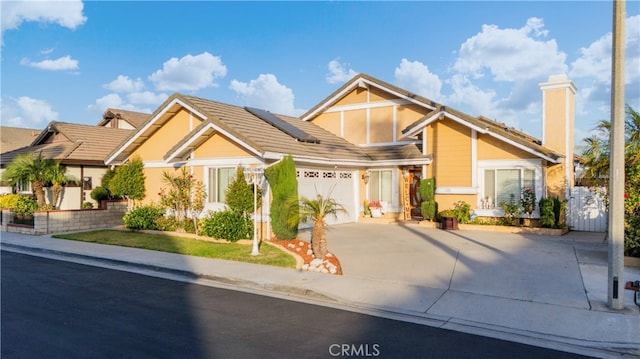 3718 Berkshire Rd, Pico Rivera, CA 90660 - view of front of house featuring concrete driveway, solar panels, a chimney, a garage, and a tile roof