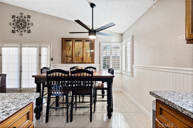 3718 Berkshire Rd, Pico Rivera, CA 90660 - dining space with vaulted ceiling, a textured ceiling, ceiling fan, wainscoting, and light tile patterned floors