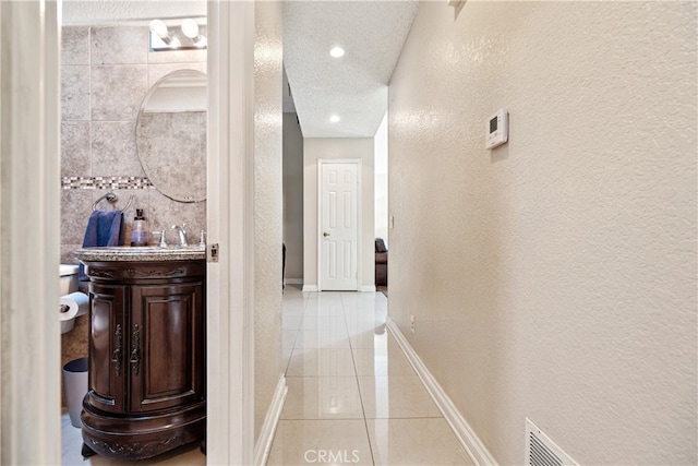 3718 Berkshire Rd, Pico Rivera, CA 90660 - hall with a textured wall, light tile patterned floors, a textured ceiling, and recessed lighting