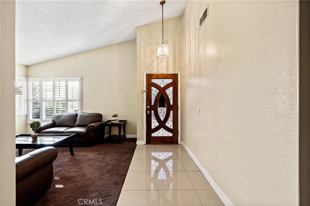 3718 Berkshire Rd, Pico Rivera, CA 90660 - foyer entrance with vaulted ceiling, a textured ceiling, light tile patterned floors, and a textured wall
