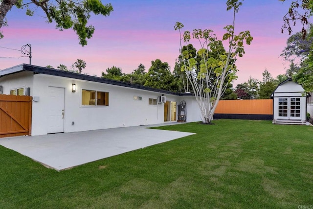 709 Puebla St, Encinitas, CA 92024 - back of house at dusk with a patio area, stucco siding, a gate, and an outbuilding