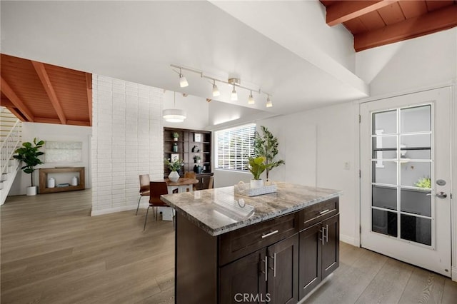 15352 Pastrana Dr, La Mirada, CA 90638 - kitchen with light wood-style floors, light stone countertops, a kitchen island, dark brown cabinets, and track lighting