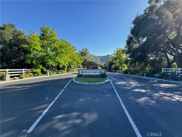 32641 Womsi Rd, Pauma Valley, CA 92061 - view of asphalt road featuring a mountain view, curbs, and view of scattered trees