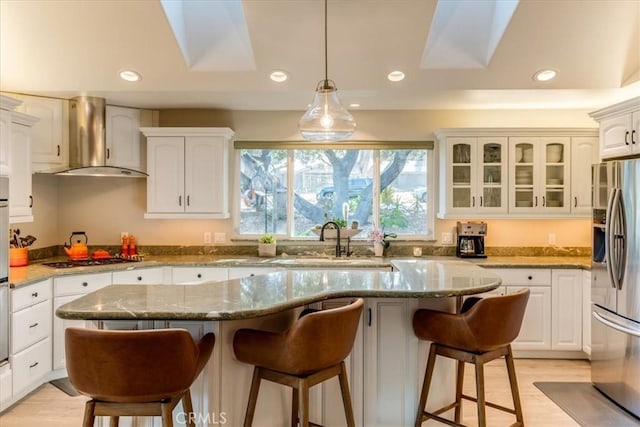 947 Calimex, Nipomo, CA 93444 - kitchen with appliances with stainless steel finishes, wall chimney range hood, a breakfast bar, recessed lighting, and white cabinets