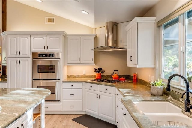 947 Calimex, Nipomo, CA 93444 - kitchen with stainless steel appliances, wall chimney range hood, healthy amount of natural light, vaulted ceiling, and light stone countertops