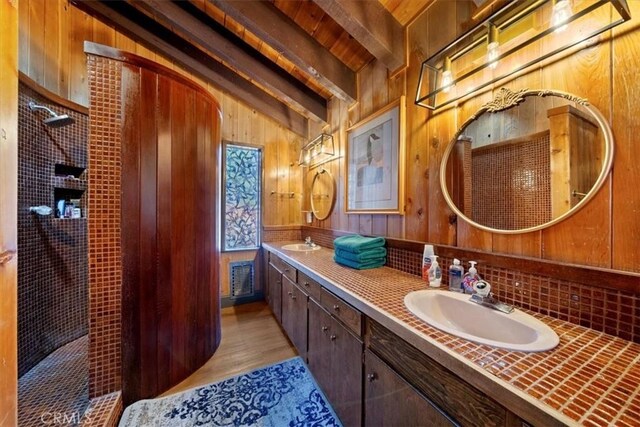 33211 Juniper Ln, Green Valley Lake, CA 92341 - full bathroom with double vanity, wooden walls, tiled shower, wood finished floors, and tasteful backsplash