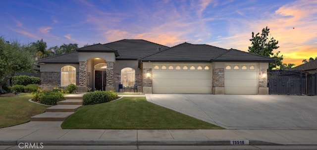 15518 Joseph Phelps Ave, Bakersfield, CA 93314 - view of front of property featuring an attached garage, driveway, stone siding, stucco siding, and a lawn