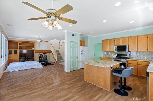 23832 Matador Way, Murrieta, CA 92562 - kitchen with appliances with stainless steel finishes, a kitchen island, light wood-type flooring, open floor plan, and ceiling fan