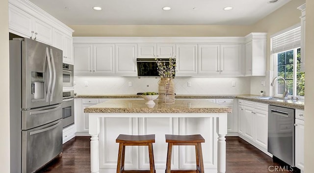 18 Via Canero, San Clemente, CA 92673 - kitchen with stainless steel appliances, white cabinetry, light stone counters, a center island, and recessed lighting