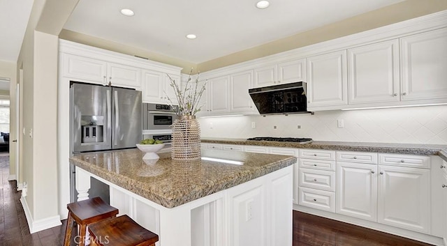 18 Via Canero, San Clemente, CA 92673 - kitchen featuring exhaust hood, light stone countertops, a kitchen island, appliances with stainless steel finishes, and white cabinetry