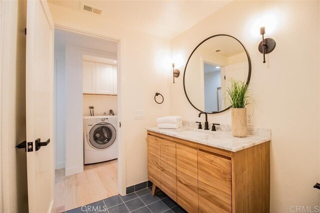 4026 Garfield St, Carlsbad, CA 92008 - bathroom featuring washer / clothes dryer, vanity, and tile patterned flooring