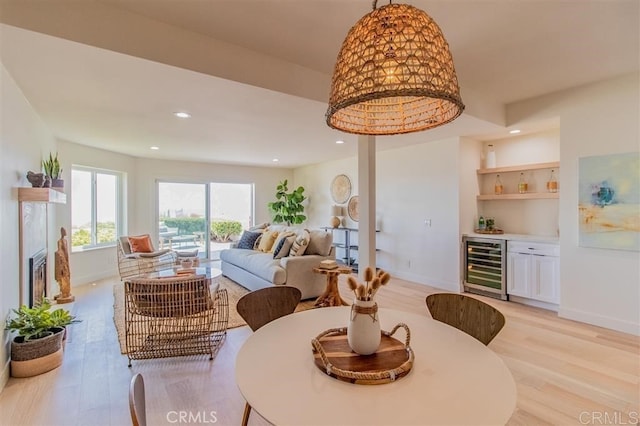 4026 Garfield St, Carlsbad, CA 92008 - dining room featuring beverage cooler, a dry bar, light wood-type flooring, a glass covered fireplace, and recessed lighting