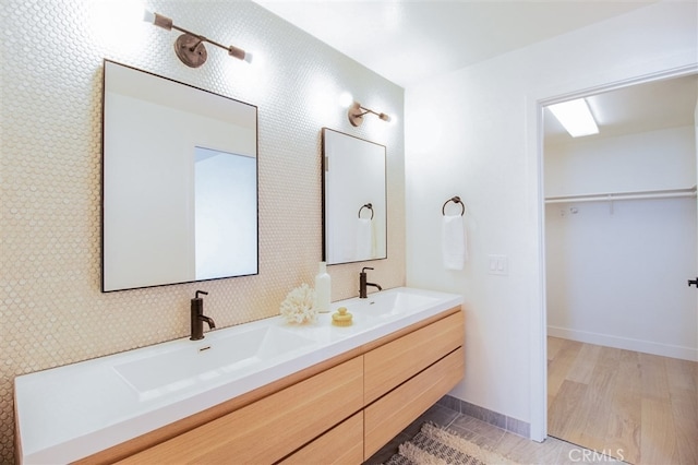4026 Garfield St, Carlsbad, CA 92008 - bathroom featuring double vanity, a spacious closet, and wood finished floors