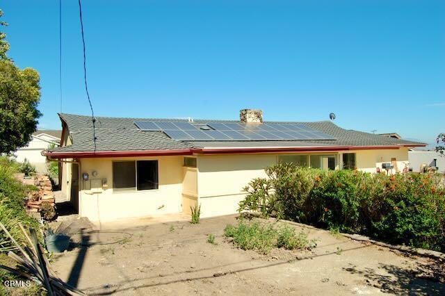 691 Via Ondulando, Ventura, CA 93003 - back of property with roof mounted solar panels, stucco siding, an attached garage, and a chimney