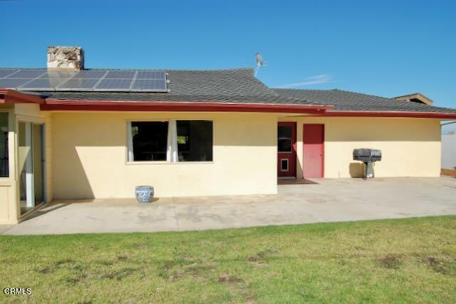 691 Via Ondulando, Ventura, CA 93003 - rear view of house with roof mounted solar panels, stucco siding, a patio, and a lawn