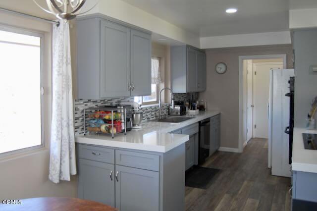 691 Via Ondulando, Ventura, CA 93003 - kitchen with dishwasher, backsplash, light countertops, freestanding refrigerator, and wood finished floors