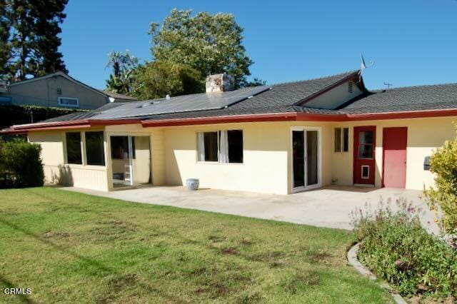 691 Via Ondulando, Ventura, CA 93003 - rear view of house featuring a yard, solar panels, a patio area, a chimney, and stucco siding