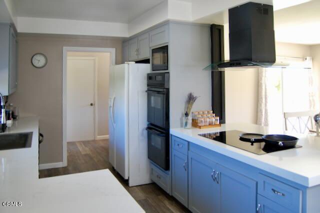 691 Via Ondulando, Ventura, CA 93003 - kitchen featuring wall chimney range hood, black appliances, light countertops, and dark wood finished floors