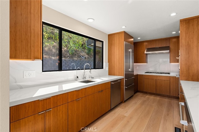 325 N Madison Ave, Monrovia, CA 91016 - kitchen featuring stainless steel appliances, brown cabinetry, range hood, decorative backsplash, and light wood finished floors