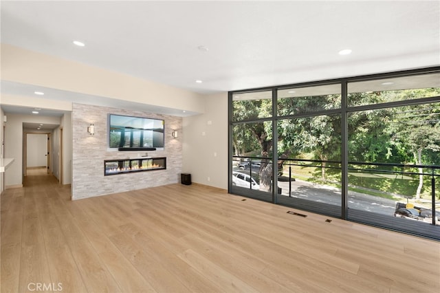 325 N Madison Ave, Monrovia, CA 91016 - unfurnished living room featuring a glass covered fireplace, wood finished floors, plenty of natural light, a wall of windows, and recessed lighting