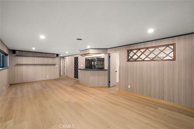 325 N Madison Ave, Monrovia, CA 91016 - unfurnished living room with light wood-type flooring, recessed lighting, wooden walls, and bar area