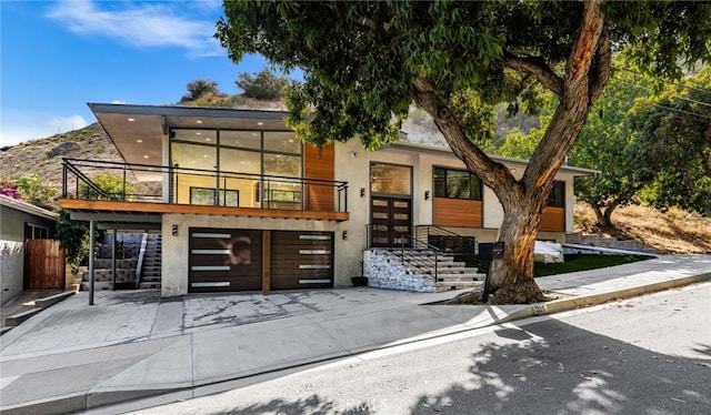 325 N Madison Ave, Monrovia, CA 91016 - contemporary house featuring an attached garage, driveway, french doors, a balcony, and stucco siding