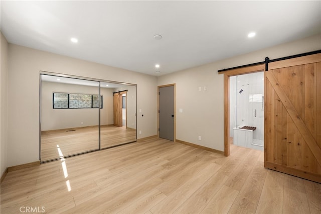325 N Madison Ave, Monrovia, CA 91016 - unfurnished bedroom featuring a barn door, light wood-style floors, recessed lighting, a closet, and ensuite bathroom