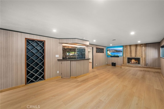 325 N Madison Ave, Monrovia, CA 91016 - unfurnished living room featuring light wood-style flooring, a large fireplace, wooden walls, and recessed lighting