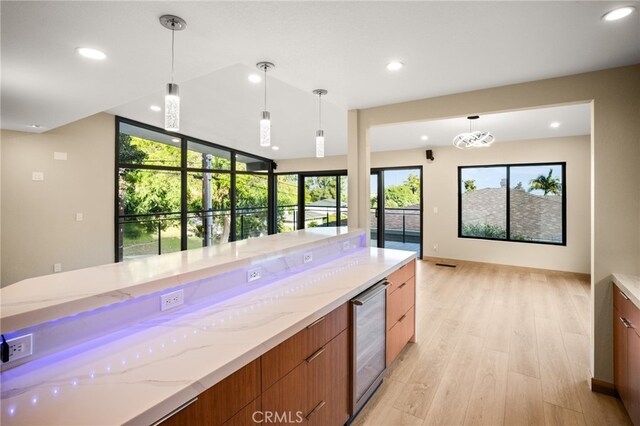 325 N Madison Ave, Monrovia, CA 91016 - kitchen with wine cooler, modern cabinets, light wood finished floors, light stone counters, and pendant lighting