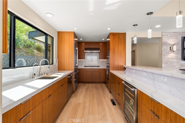 325 N Madison Ave, Monrovia, CA 91016 - kitchen featuring wine cooler, brown cabinets, light wood-type flooring, appliances with stainless steel finishes, and recessed lighting