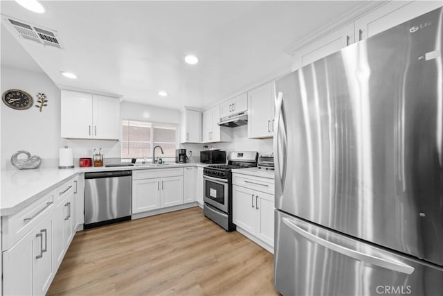 18536 Mescal St, Rowland Heights, CA 91748 - kitchen with stainless steel appliances, under cabinet range hood, white cabinets, and recessed lighting