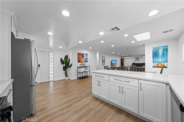 18536 Mescal St, Rowland Heights, CA 91748 - kitchen with stainless steel appliances, recessed lighting, a skylight, light wood finished floors, and white cabinets