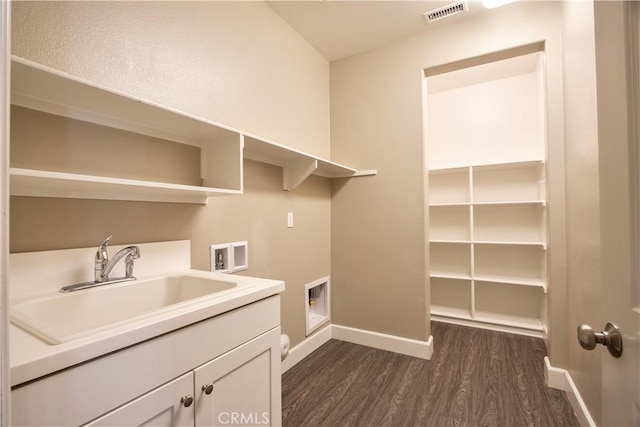 27974 Garda Ct, Menifee, CA 92585 - washroom featuring washer hookup, dark wood-style flooring, and cabinet space