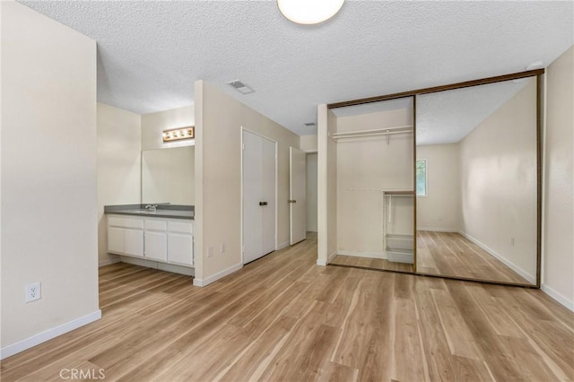 2321 S Magnolia Ave Unit 6E, Ontario, CA 91762 - unfurnished bedroom with light wood-style flooring and a textured ceiling