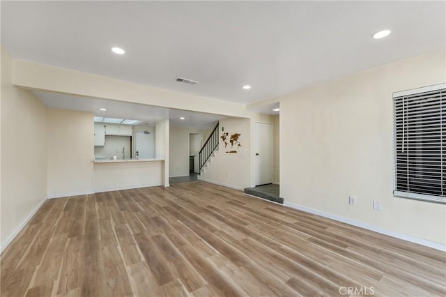 2321 S Magnolia Ave Unit 6E, Ontario, CA 91762 - unfurnished living room featuring light wood-type flooring, stairway, and recessed lighting