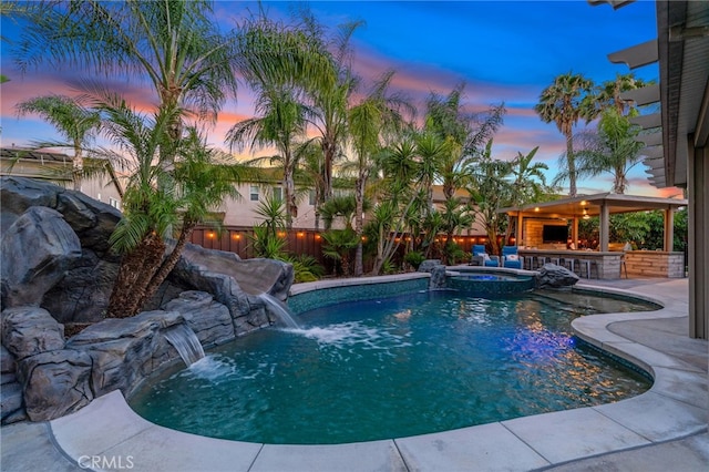 14131 Apple Grove Ct, Eastvale, CA 92880 - pool at dusk with a fenced backyard, a patio, and a pool with connected hot tub