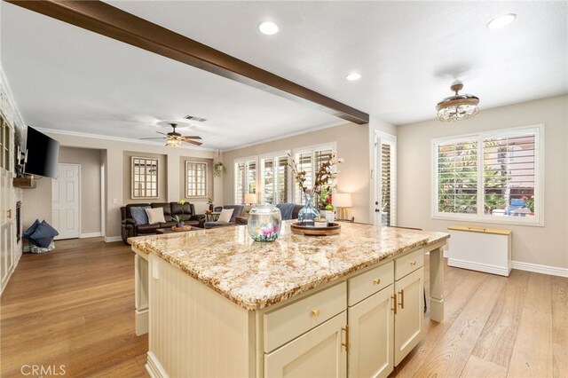 14131 Apple Grove Ct, Eastvale, CA 92880 - kitchen featuring light wood-style floors, recessed lighting, light stone countertops, a kitchen island, and ceiling fan